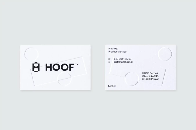 Two white business cards featuring black text and logo, one with contact information, circles and lines design; plain background.