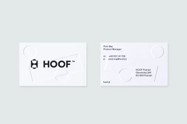 Two white business cards featuring embossed geometric shapes and the black HOOF logo on a neutral grey background.