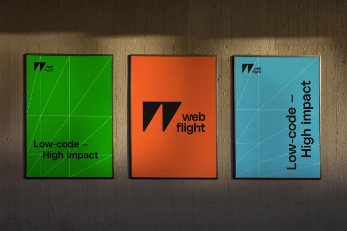 Three framed brand identity posters for WebFlight mounted on a textured concrete wall with overhead lighting