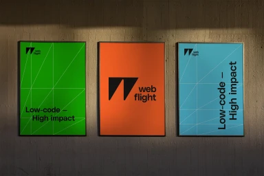 Three framed brand identity posters for WebFlight mounted on a textured concrete wall with overhead lighting