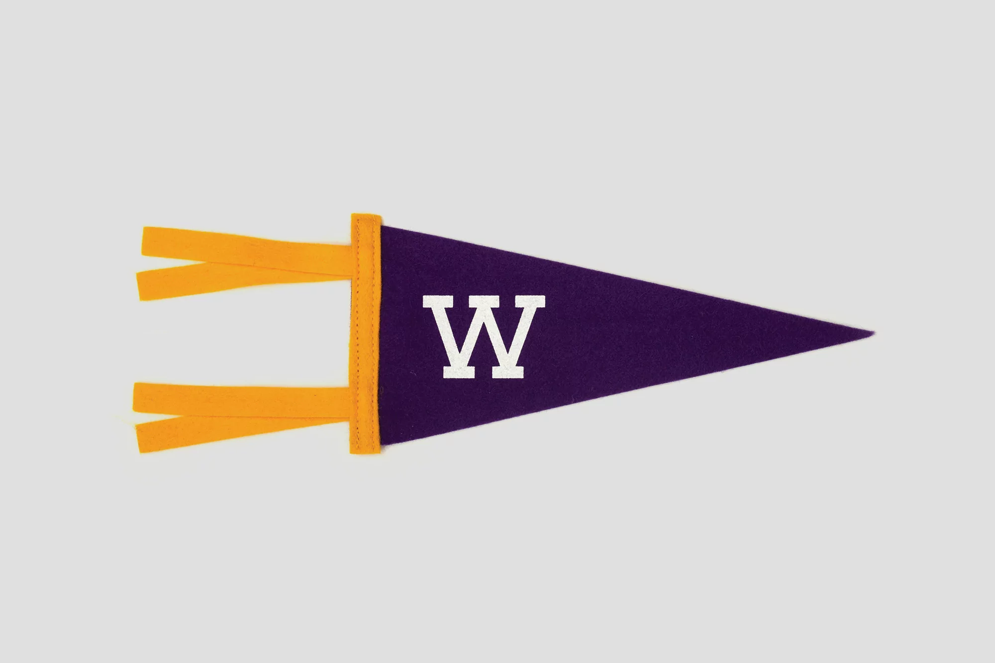 Purple and gold University of Washington pennant with a white letter 'W' displayed on a light gray background. College pride.