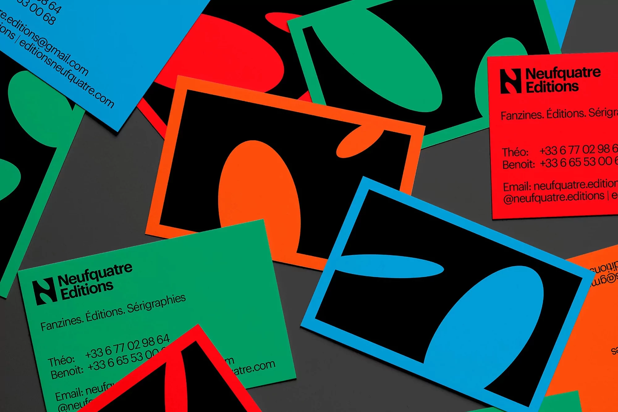 Flat lay of colorful branded business cards and promotional flyers featuring bold geometric shapes and typography
