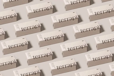 A repeating grid pattern of rectangular beige product boxes branded with black typography against a light background