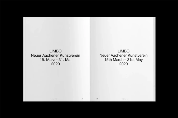 Opened book spread featuring text in English and German, black text on white pages, viewed overhead on a black background. 