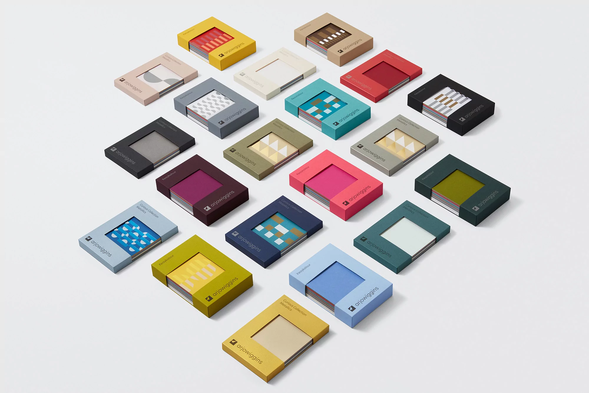 Array of colorful Arjowiggins paper sample sets arranged on a white surface, offering a variety of patterns and color palettes.