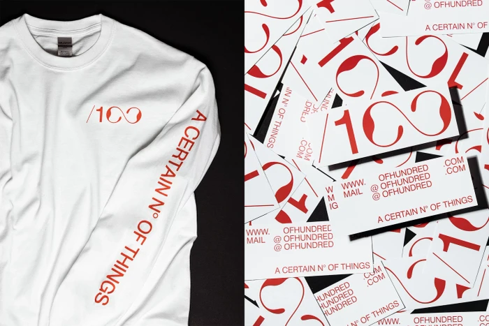 White long-sleeve t-shirt with red branding next to scattered printed cards and labels for 100