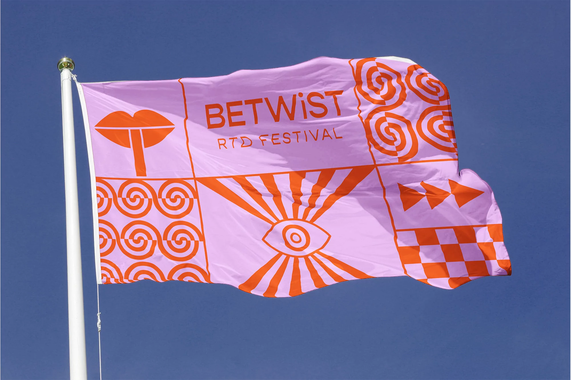Pink flag on a pole featuring orange graphic designs like lips, eyes, spirals, triangles, checkerboard pattern, and 'BETWIST RTD FESTIVAL' text.