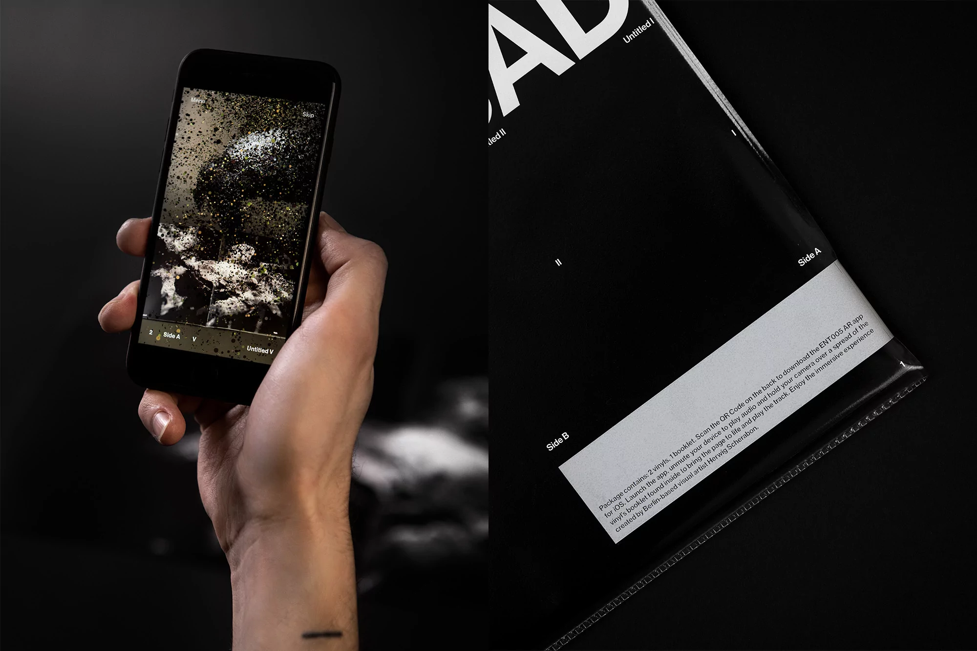 Hand holds smartphone displaying abstract art; black vinyl record with white text and clear plastic sleeve on black surface.