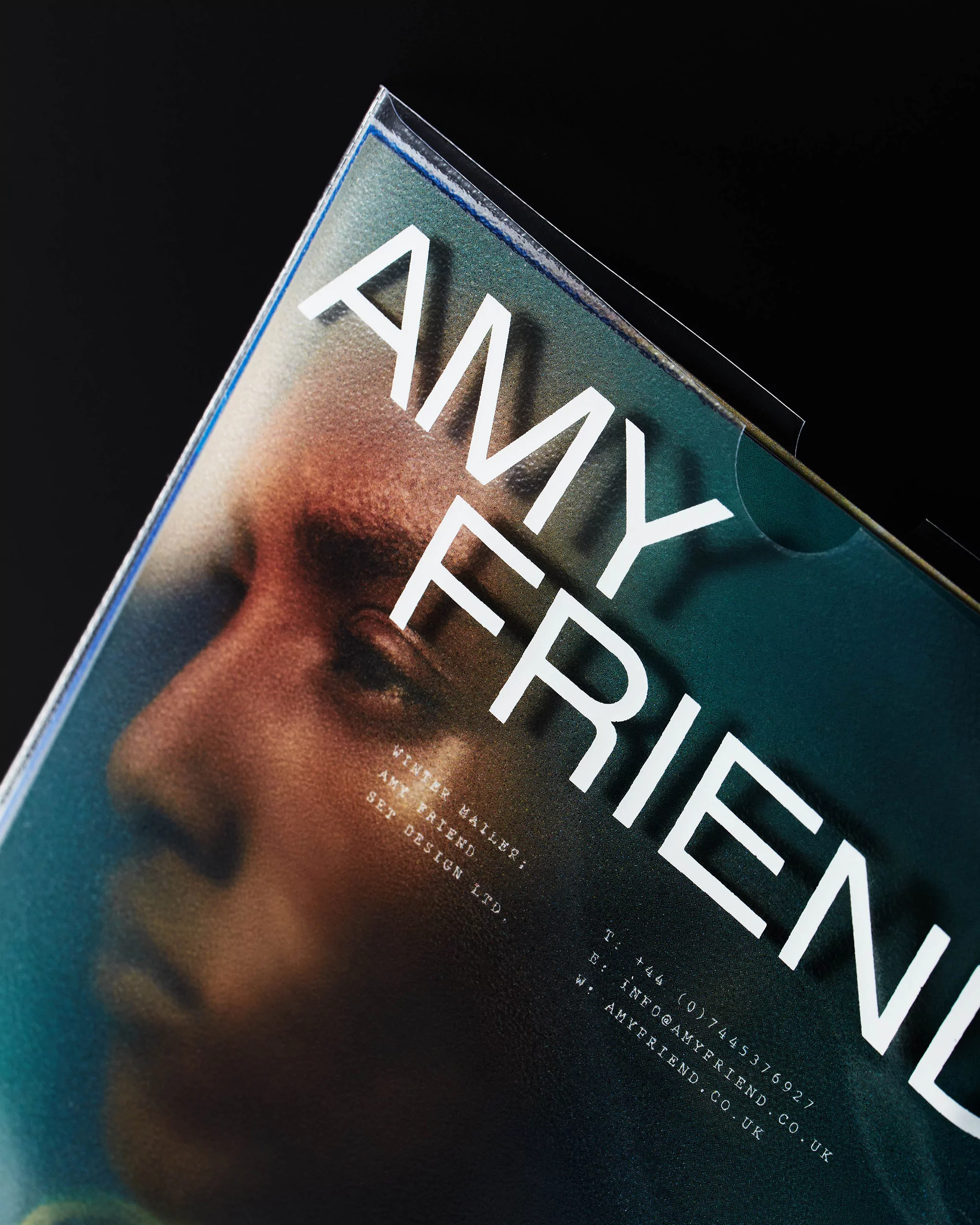 Close-up of a book cover featuring a portrait of a person with the title AMY FRIEND and contact information printed on the right side.