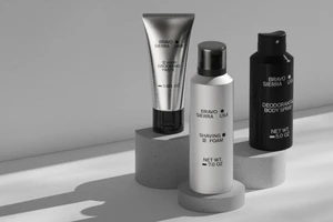 Product packaging set featuring Bravo Sierra grooming paste, shaving foam, and body spray on concrete pedestals