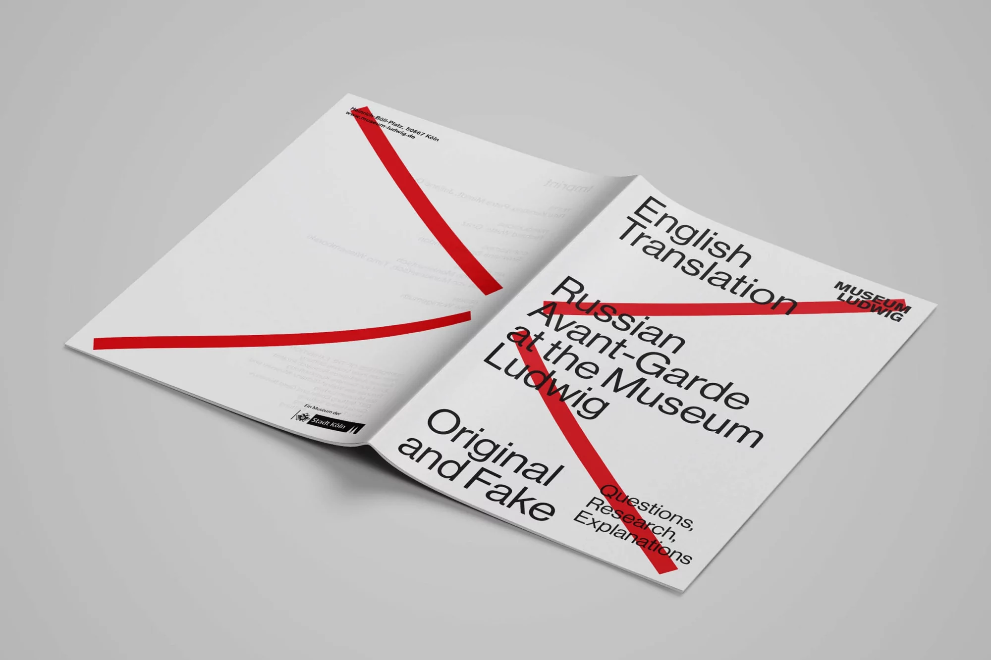Open book on a gray background featuring cover artwork with red lines and black typography, including the words 'English Translation'.