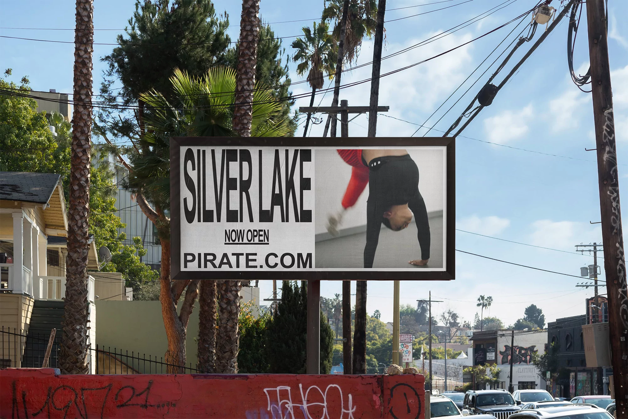 Outdoor billboard in Silver Lake, Los Angeles, featuring an ad with a person doing a handstand, set against a sunny urban landscape.