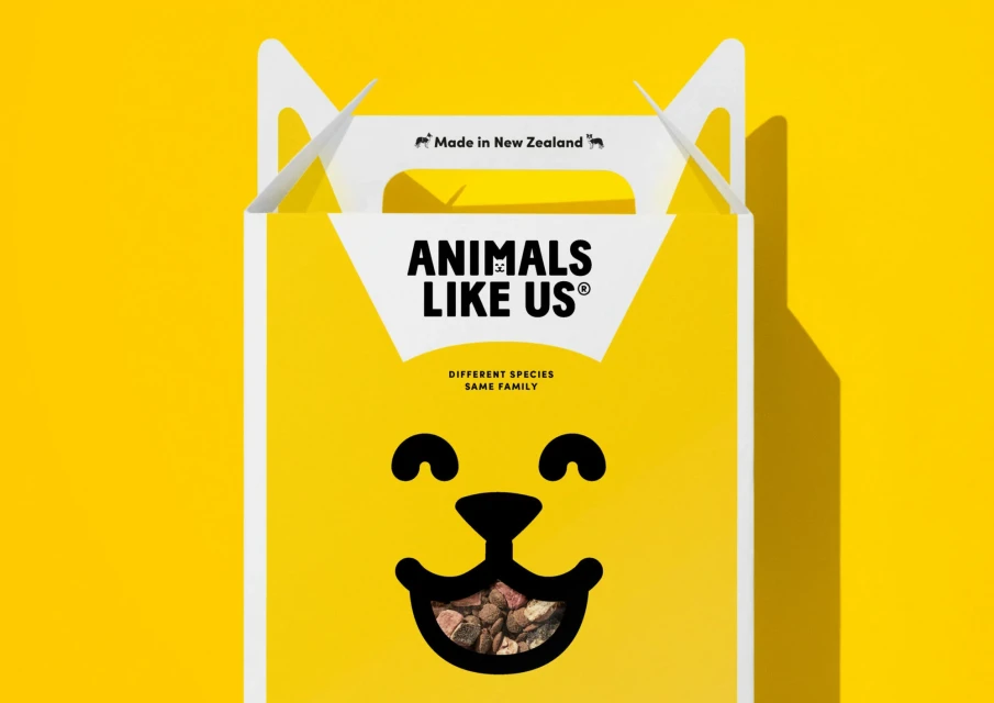 A yellow box for Animals Like Us brand with a cat face and tagline that reads: Different Species, Same Family, New Zealand made