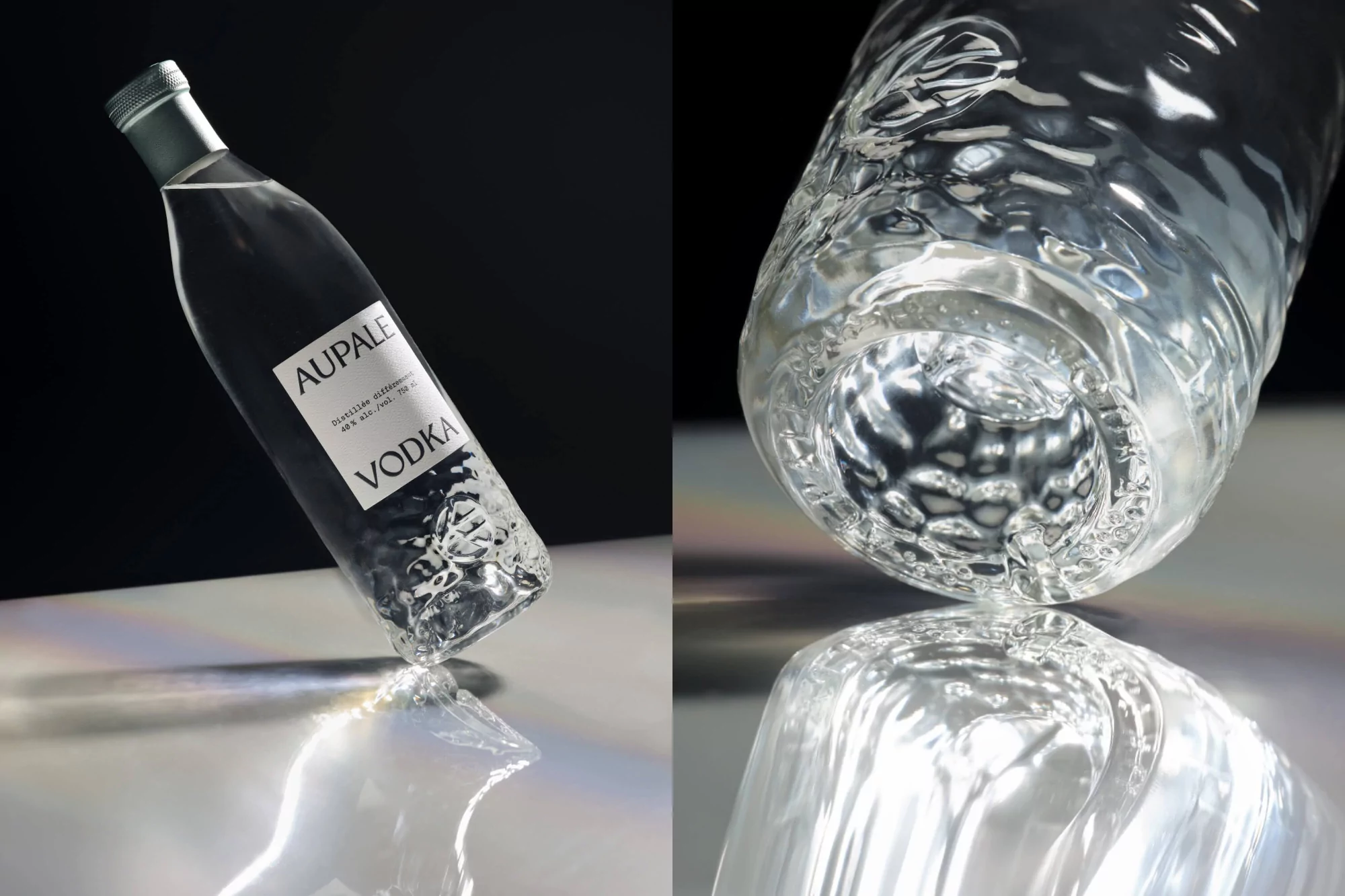 A clear glass bottle of Aupale Vodka is displayed on a reflective surface against a dark background in a product shot. 