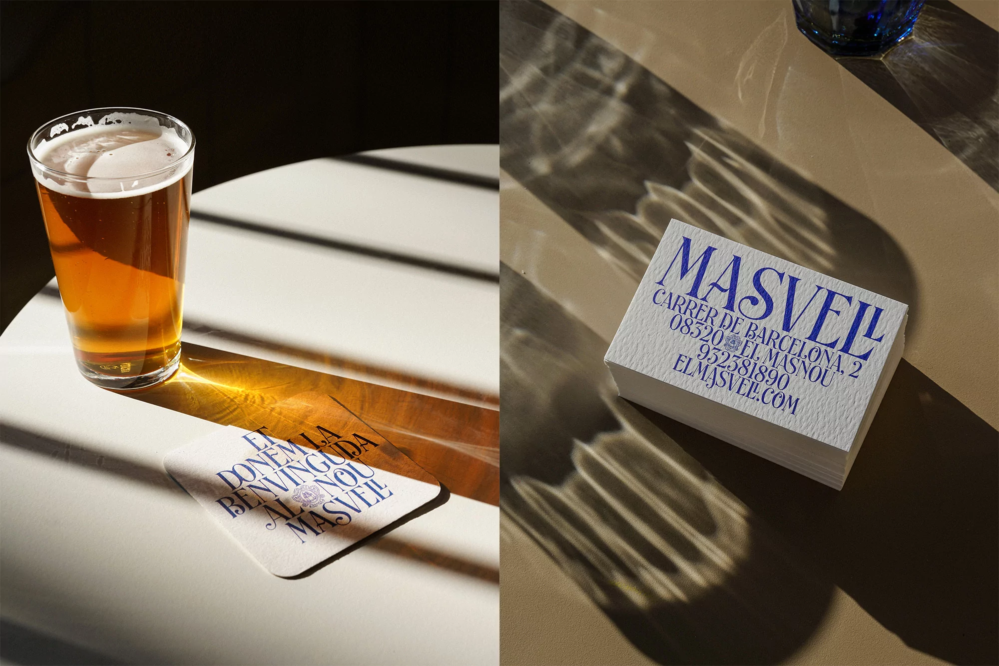 Still life shot of a pint of beer and a stack of business cards with blue text on a white table, illuminated by sunlight.