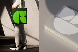 Person holding green graphic tote bag standing next to a book titled Glyphs 3 Handbook 2021