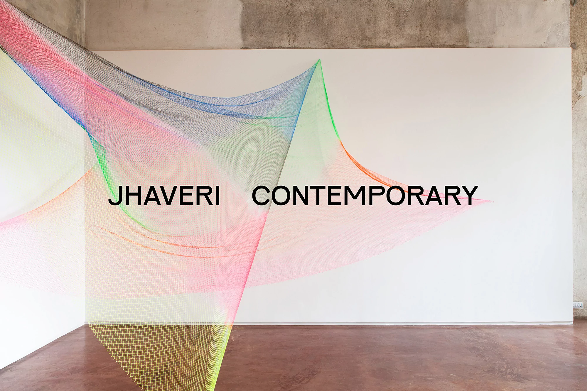 Abstract art installation featuring colorful netting suspended in an indoor space, complemented by text overlay for 'Jhaveri Contemporary'.