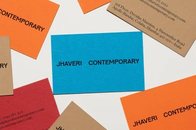 Flat lay of colourful Jhaveri Contemporary business cards on white background