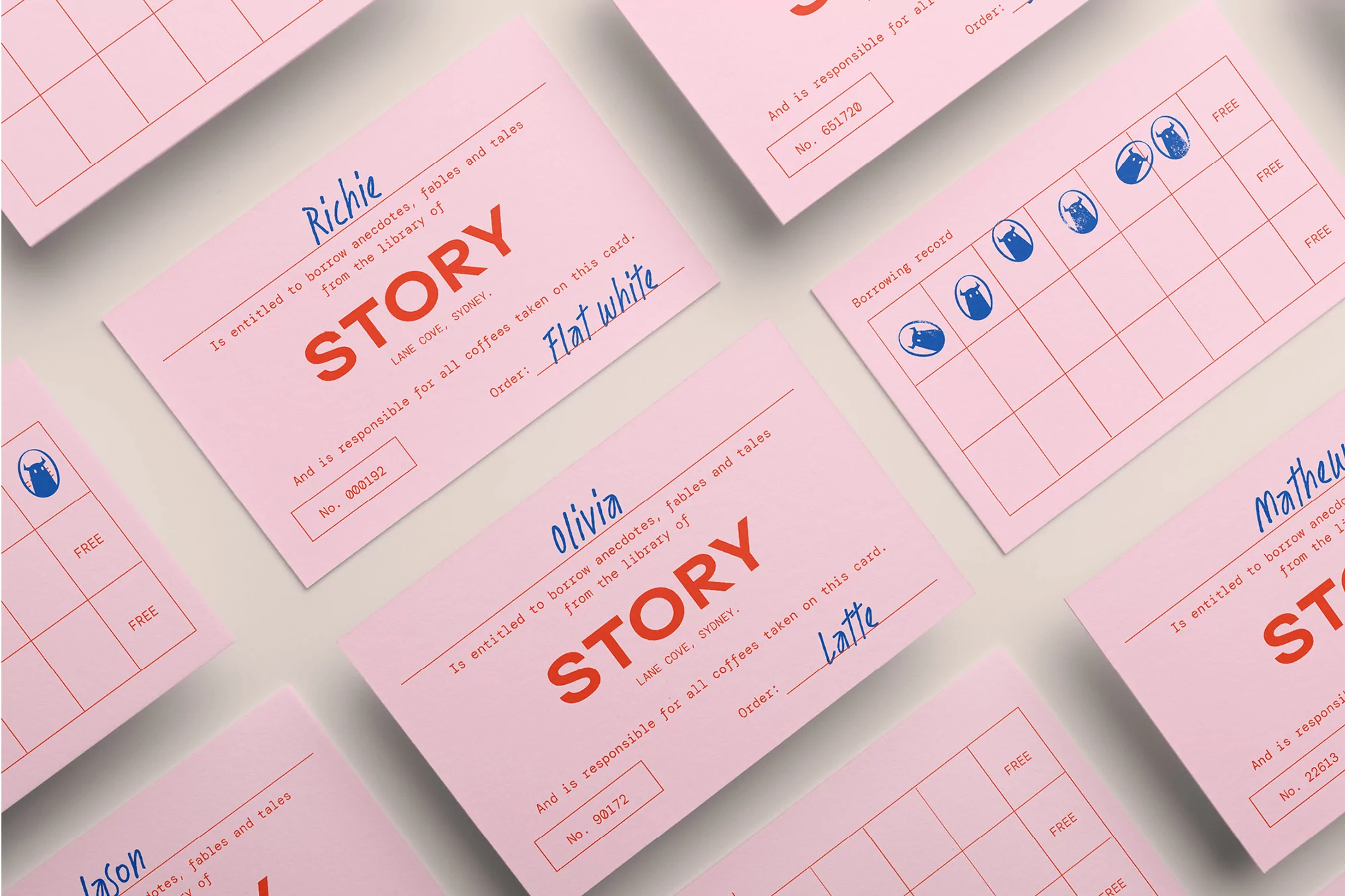 Close-up shot of pink library-style cards with the word "STORY" printed on each, names written on top, order descriptions.