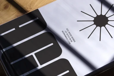 Close up shot of ACC brand identity packaging with bold black typography and a starburst icon on a light surface.