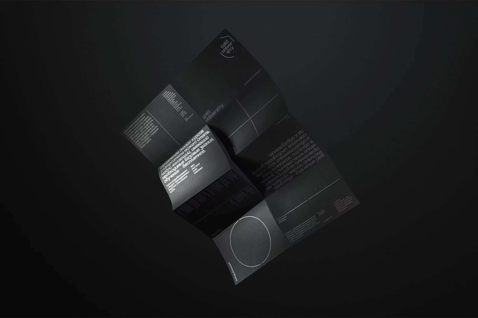 Promotional material from Gold University with text on the brochure in black and white and folded on top of a black background.