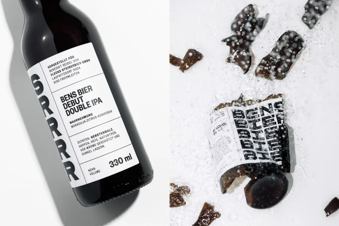A bottle of Bens Bier Double IPA sits beside shattered glass, water droplets and a damaged bottle label on a white surface.