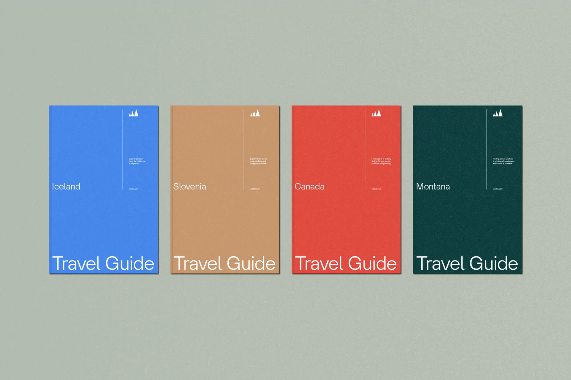 Four travel guide books for Iceland, Slovenia, Canada and Montana, each a different color, lined up on a solid grey background.