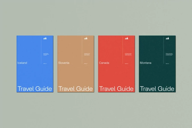 Four travel guide books for Iceland, Slovenia, Canada and Montana, each a different color, lined up on a solid grey background.