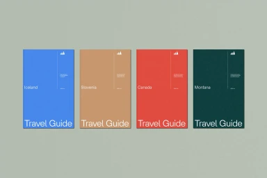Four minimalist travel guide books in blue, tan, red, and dark green arranged horizontally on a neutral light grey surface.