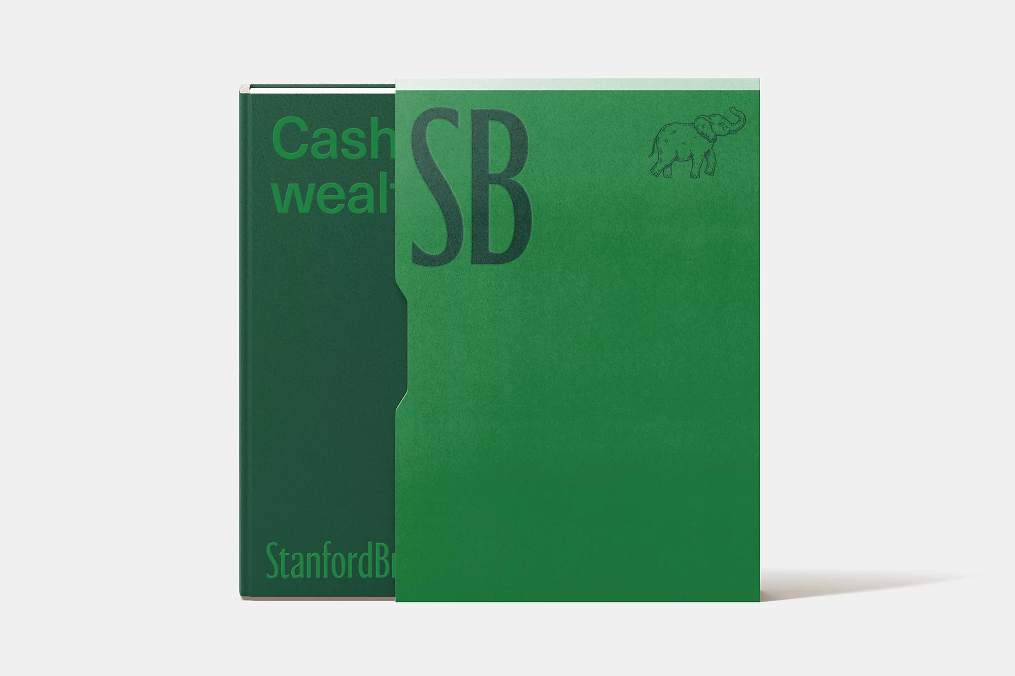 Two green hardcover books with text and an elephant drawing, set against a neutral background in a studio setting.