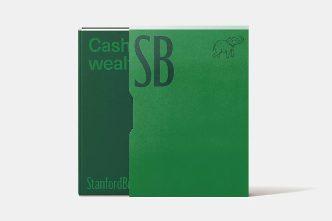 Two green hardcover books with text and an elephant drawing, set against a neutral background in a studio setting.