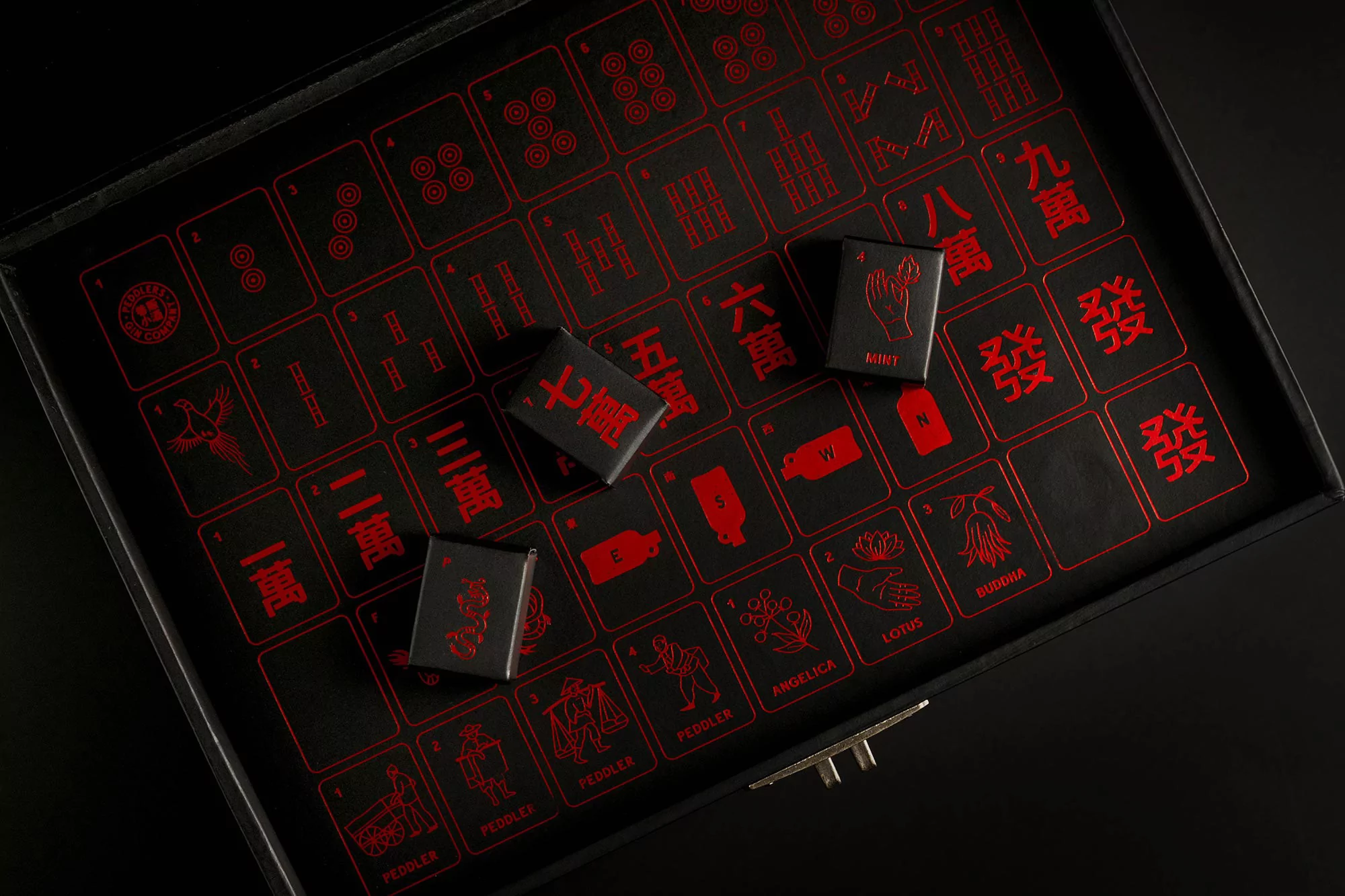Close-up of a Mahjong game set in black and red. The black tiles feature red Chinese characters and symbols laid out on a board.