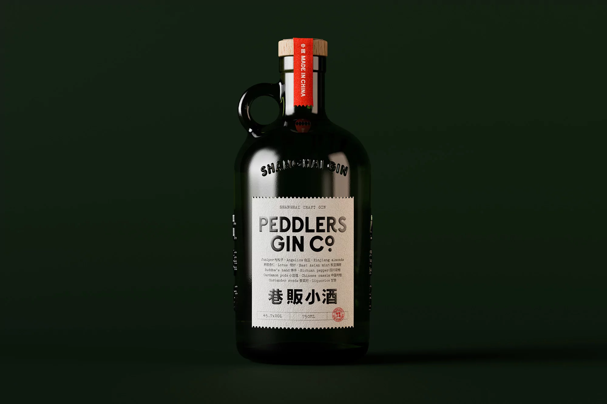 Studio shot of a dark glass gin bottle with a handle and a red label with white text on the neck set against a dark green background.