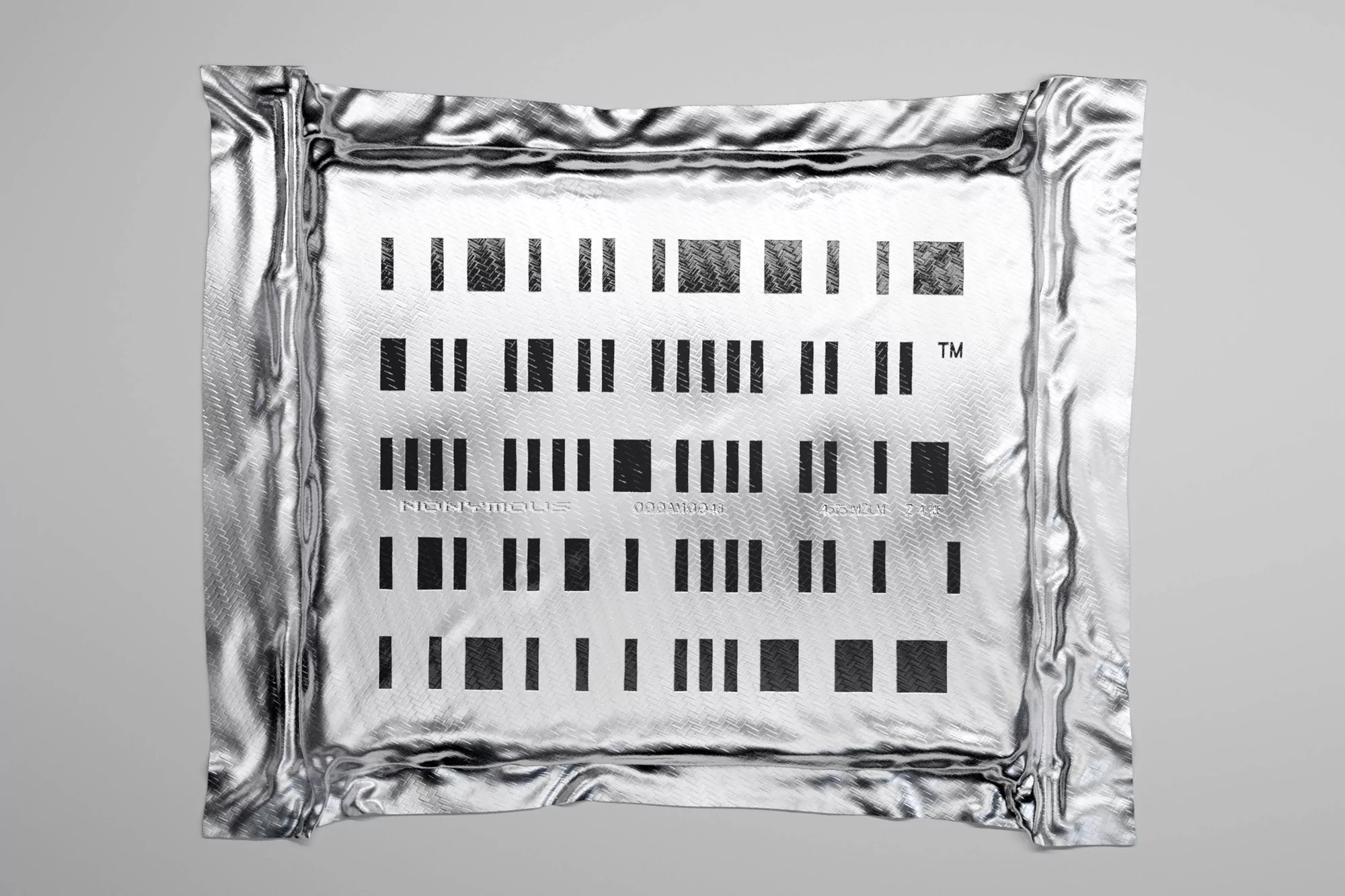 Abstract artwork features black barcode-like patterns on a reflective silver fabric, presented on a neutral grey background, flat lay.
