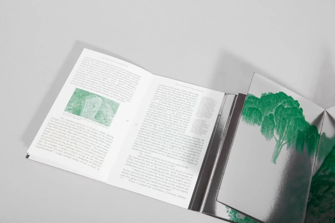 An open book displaying typography and a green illustration on a clean white surface