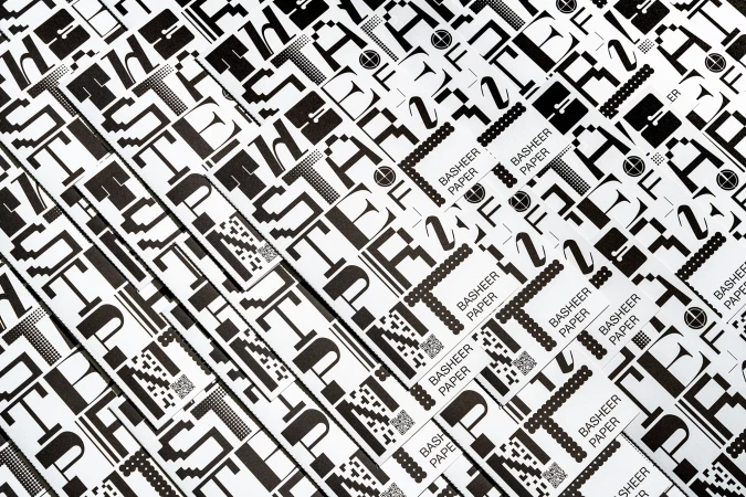 Overhead shot of repeating Basheer Paper letterhead design in black and white, creating a modern, abstract pattern effect for backgrounds.