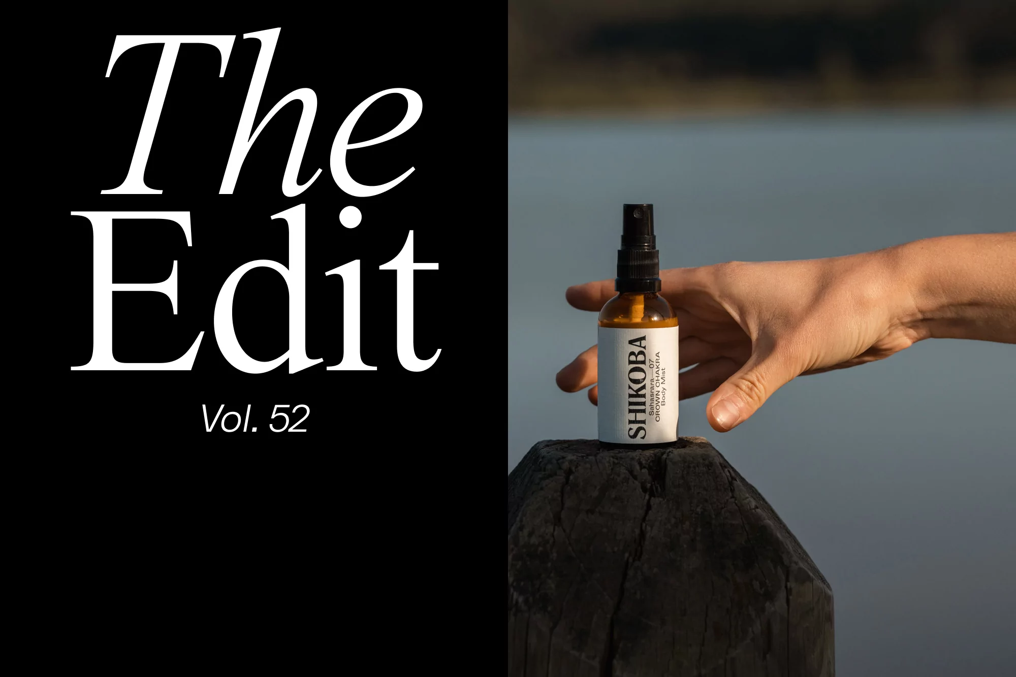Amber glass spray bottle of SHIKOBA body mist rests on weathered wood post, against blurred lake backdrop, held by human hand.