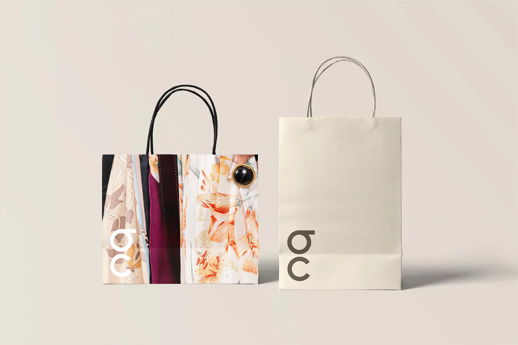 Two shopping bags are displayed against a neutral background. One has a floral pattern, the other a brand logo. Both bags are off-white.