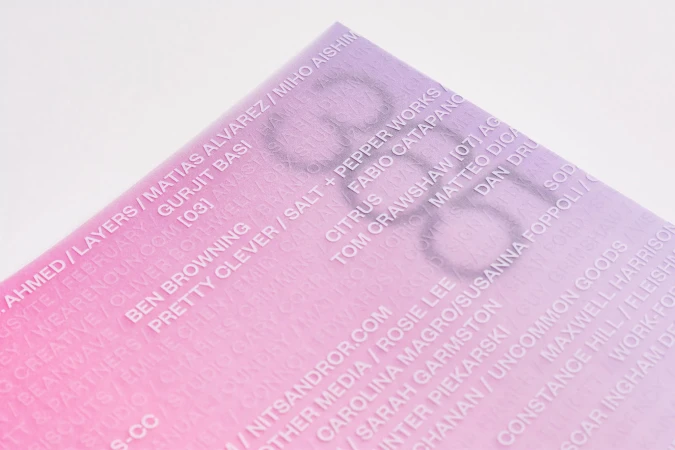 Close-up of a program or booklet in pink and purple gradient with list of names and design studio, photography studio, and foundry credits.