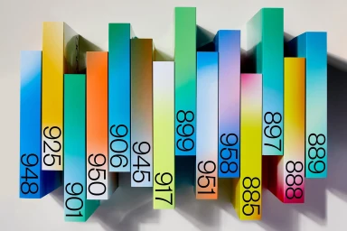Colorful vertical paper spines with black numbers arranged horizontally against a neutral white background