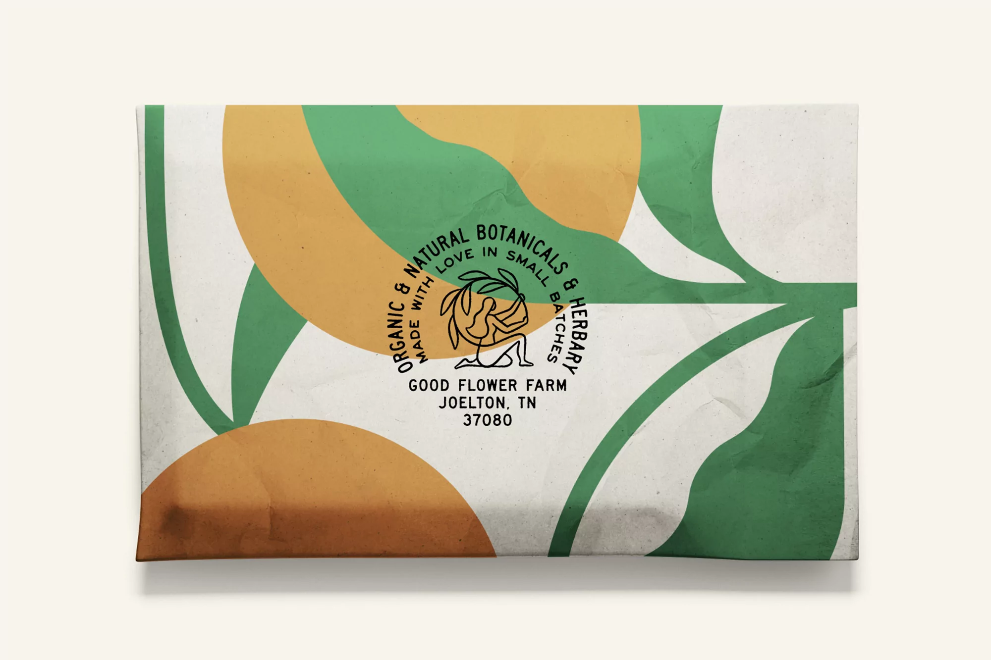 Overhead view of a white box featuring an illustrated design of organic botanical elements in shades of green and yellow-orange.