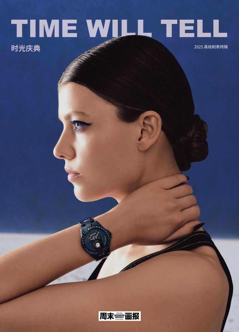 Fashion magazine cover featuring a woman wearing a black wristwatch against a blue and white abstract background.