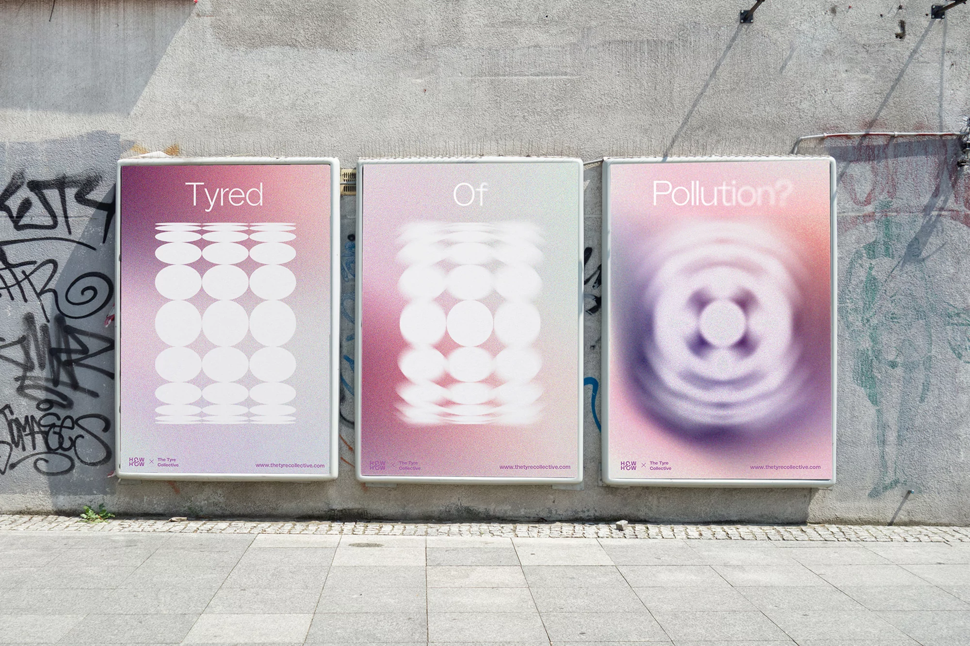 Three posters with abstract art mounted on a concrete wall outside featuring geometric designs and pink, purple, and white color gradients.