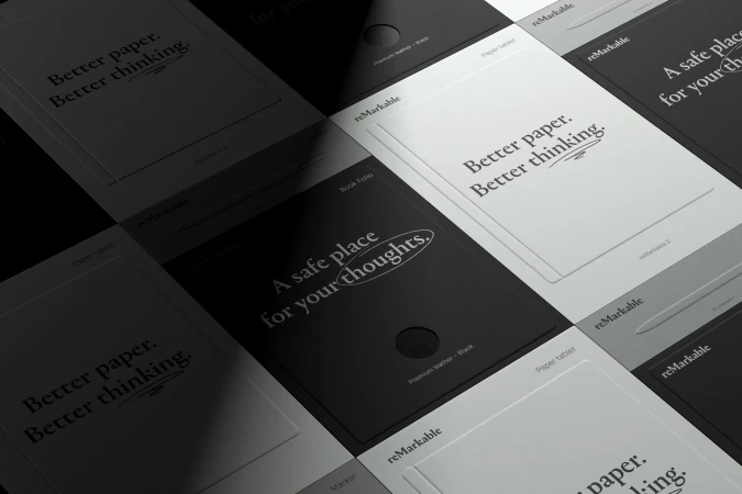 Several black and white Remarkable paper tablets arranged in a grid pattern, some with text on the screens and one with a pen.