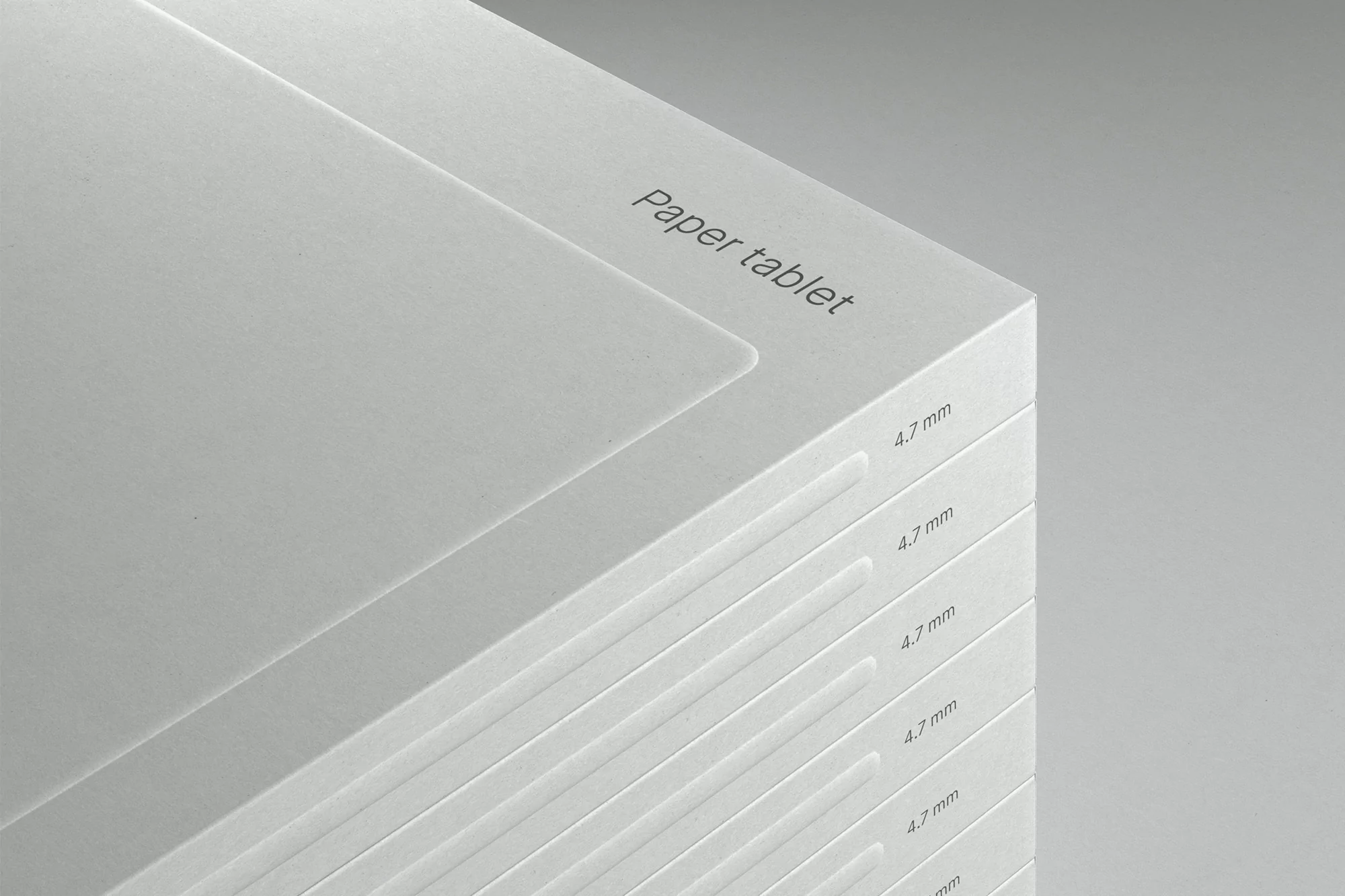 Stack of white paper tablets with minimalist design, showcasing clean lines, subtle typography, and a modern, neutral aesthetic.