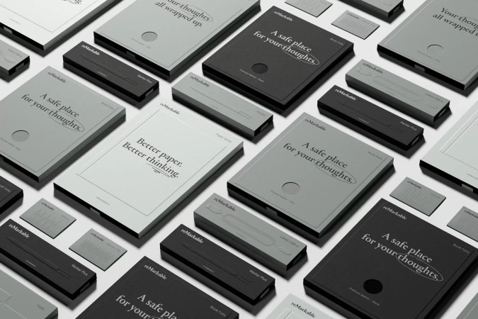 Monochromatic image featuring multiple reMarkable tablets and pen accessories in various grayscale shades on a neutral background. Product photography.
