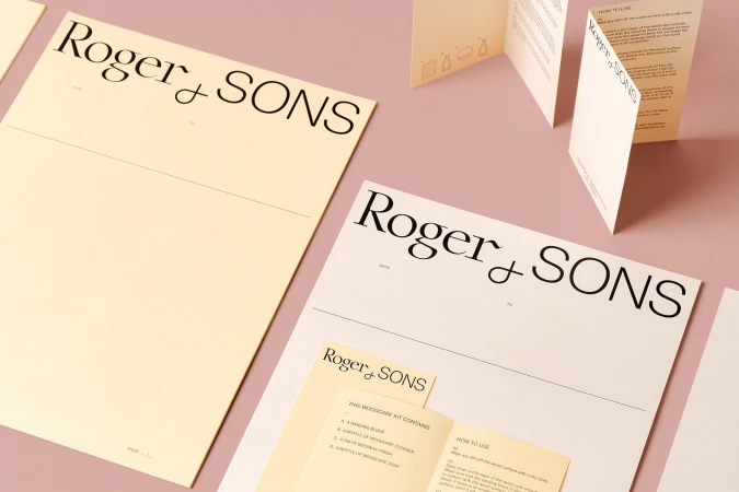 Promotional image showcasing Roger & Sons brand stationery, including letterhead and instruction pamphlets, on a pink background.