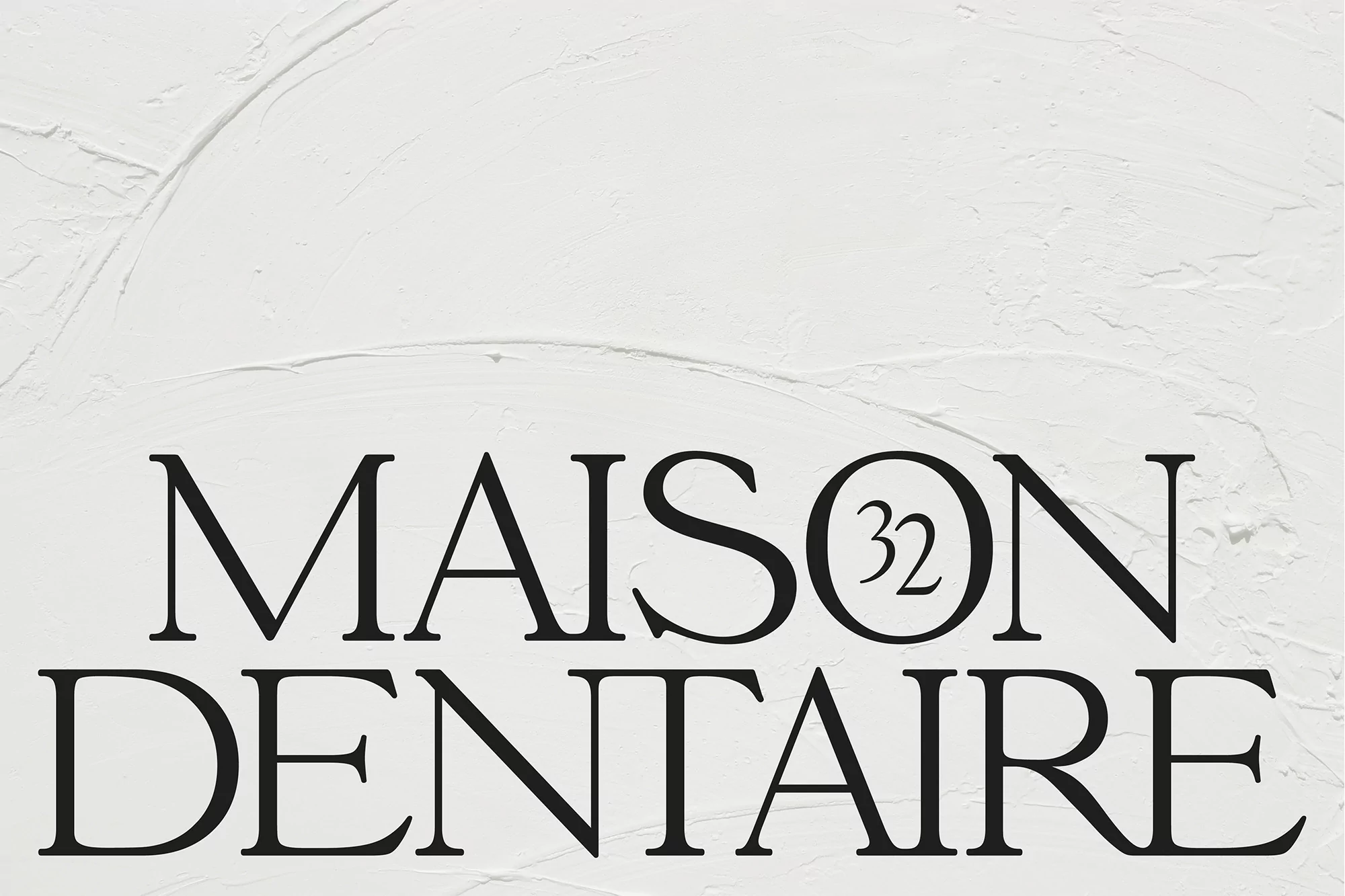 Elegant 'Maison Dentaire 32' logo in black serif font on textured white background, evoking sophistication and dental care.