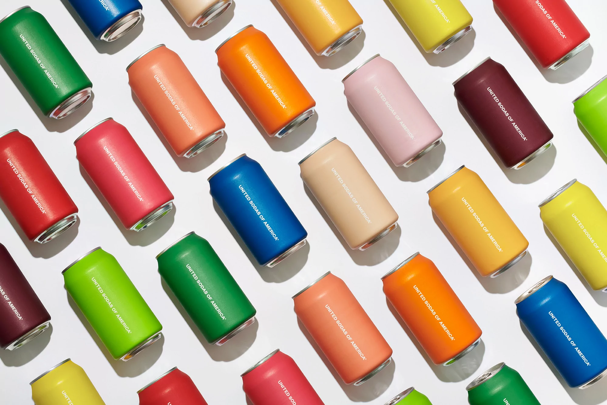 Colorful array of soda cans arranged in a grid pattern on a white background, featuring various hues and the 'United Sodas of America' logo.