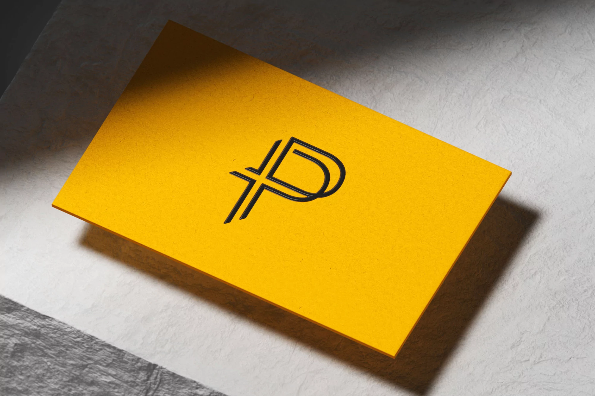 A bright yellow card with a minimalist double-lined letter 'P' logo rests on a textured light gray surface, casting a subtle shadow.